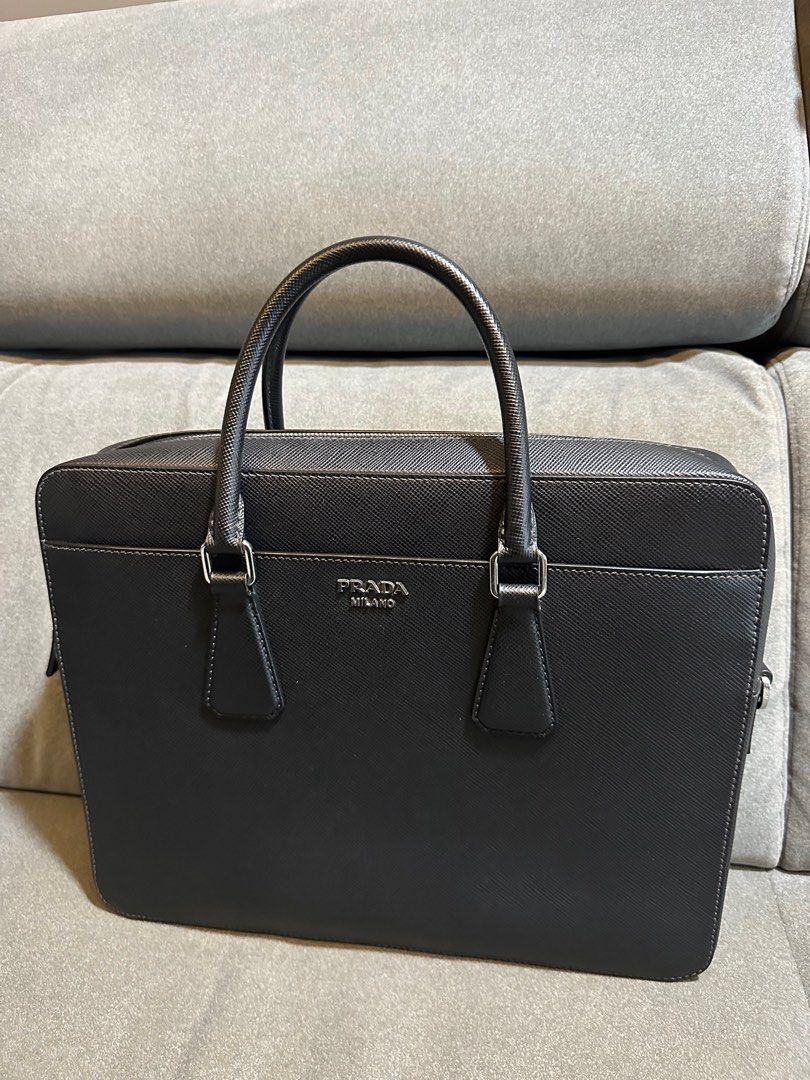 Prada Saffiano Leather Briefcase / Business Bag (Category: Bags & Wallets) located in Singapore. Submitted by cjyong (Listing ID 1353068127, Image 2). Description: Prada briefcase as good as new. Used only for a couple of times. Shoulder strap is new and unused before. Briefcase in Saffiano leather. Prada lettering in metal..