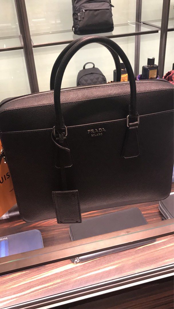 Prada Saffiano Leather Briefcase / Business Bag (Category: Bags & Wallets) located in Singapore. Submitted by cjyong (Listing ID 1353068127, Image 3). Description: Prada briefcase as good as new. Used only for a couple of times. Shoulder strap is new and unused before. Briefcase in Saffiano leather. Prada lettering in metal..