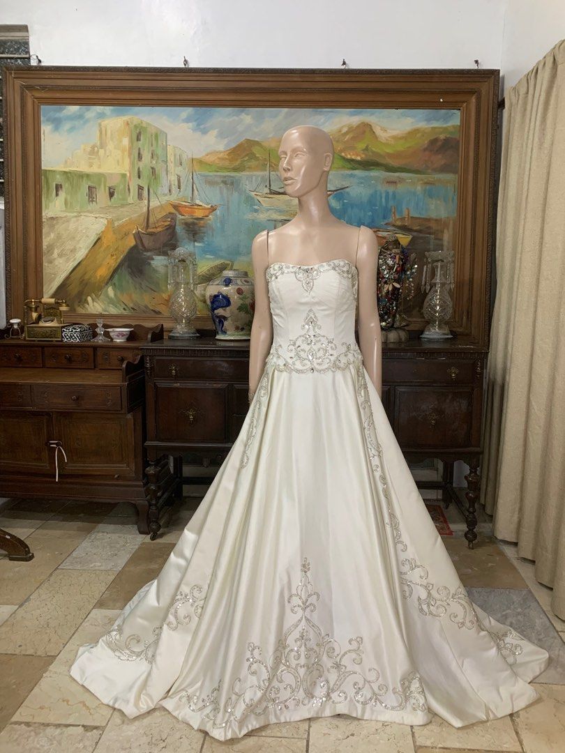 Stunning Embroidered Mikado Wedding Gown (Category: Evening dresses & gowns) located in Carmona. Submitted by fashionlibraryph (Listing ID 1353066704, Image 3). Description: This stunning wedding gown is crafted from luxurious Mikado fabric, offering a structured yet elegant silhouette. The strapless bodice features a subtle sweetheart neckline adorned with intricate silver embroidery and beadwork, accentuating the bust and waistline with a regal