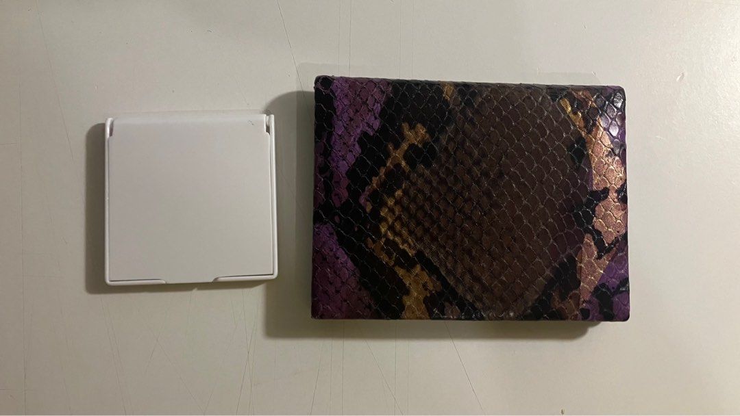 Two Compact Mirrors - One with Snakeskin Pattern (Category: Home & Furniture) located in Etobicoke. Submitted by sunflower2100 (Listing ID 1354787572, Image 2). Description: two small, foldable mirrors. One features a white plastic case. The other has a black case with a snakeskin-textured purple and brown cover. $1/each.