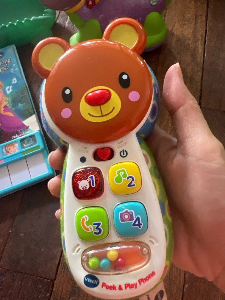 Vtech Peek & Play Phone (Category: Infant Playtime) located in San Juan City. Submitted by usimportedgoods08 (Listing ID 1354783377, Image 3). Description: Colourful phone features 4 press buttons introducing feelings, numbers, colours and first words. Includes 3 happy songs and 15 melodies. Ring! Ring! Hello, who’s calling? The Peek & Play Phone is a fun and exciting way for little ones to use their imaginations and encourages pretend play. This