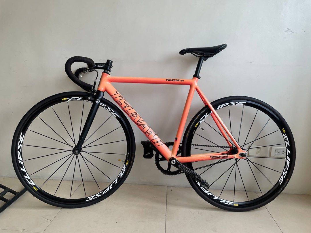 Tsunami Fixie (Racing Bike) (Category: Bicycles) located in Pasig City. Submitted by nysabelleee (Listing ID 1354951399, Image 1). Description: ⚠️PLEASE READ⚠️ Tsunami Fixie Racing Bike ⁃ Tsunami Pioneer Size 52 w/ Badge ⁃ Tsunami HS, Mountain Peak SC ⁃ The Project Fork 7.5 Steerer Tube ⁃ The Project Drop Bar Size 40 w/ Bartape ⁃ Wake Stem 90mm +17 ⁃ stock seatpost 27.2 ⁃ Fabric Saddle ⁃ Sram Omnium Crankset ⁃ Izumi Jet Black w/ Gold Pin Chain ⁃ 