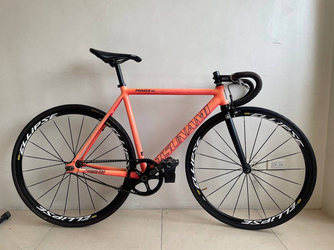 Tsunami Fixie (Racing Bike) (Category: Bicycles) located in Pasig City. Submitted by nysabelleee (Listing ID 1354951399, Image 2). Description: ⚠️PLEASE READ⚠️ Tsunami Fixie Racing Bike ⁃ Tsunami Pioneer Size 52 w/ Badge ⁃ Tsunami HS, Mountain Peak SC ⁃ The Project Fork 7.5 Steerer Tube ⁃ The Project Drop Bar Size 40 w/ Bartape ⁃ Wake Stem 90mm +17 ⁃ stock seatpost 27.2 ⁃ Fabric Saddle ⁃ Sram Omnium Crankset ⁃ Izumi Jet Black w/ Gold Pin Chain ⁃ 