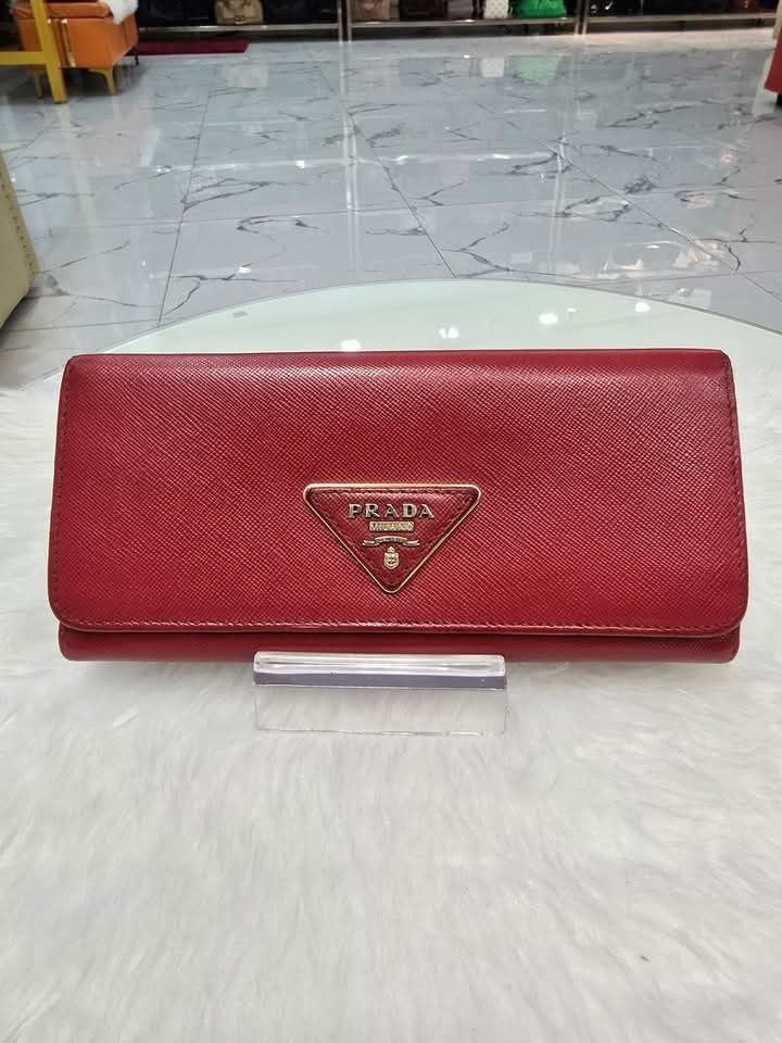 💜 Prada Saffiano Triangle Continental Flap Wallet Fuoco (Category: Luxury Bags & Wallets) located in Lala. Submitted by mohsin0825 (Listing ID 1355389970, Image 2). Description: Prada Saffiano Triangle Continental Flap Wallet Fuoco P11,990+sf Guaranteed Authentic 💯 In good condition/ 📍Not affiliated or associated with any brand posted. All brands, product names and logos are the property of their respective original brand.