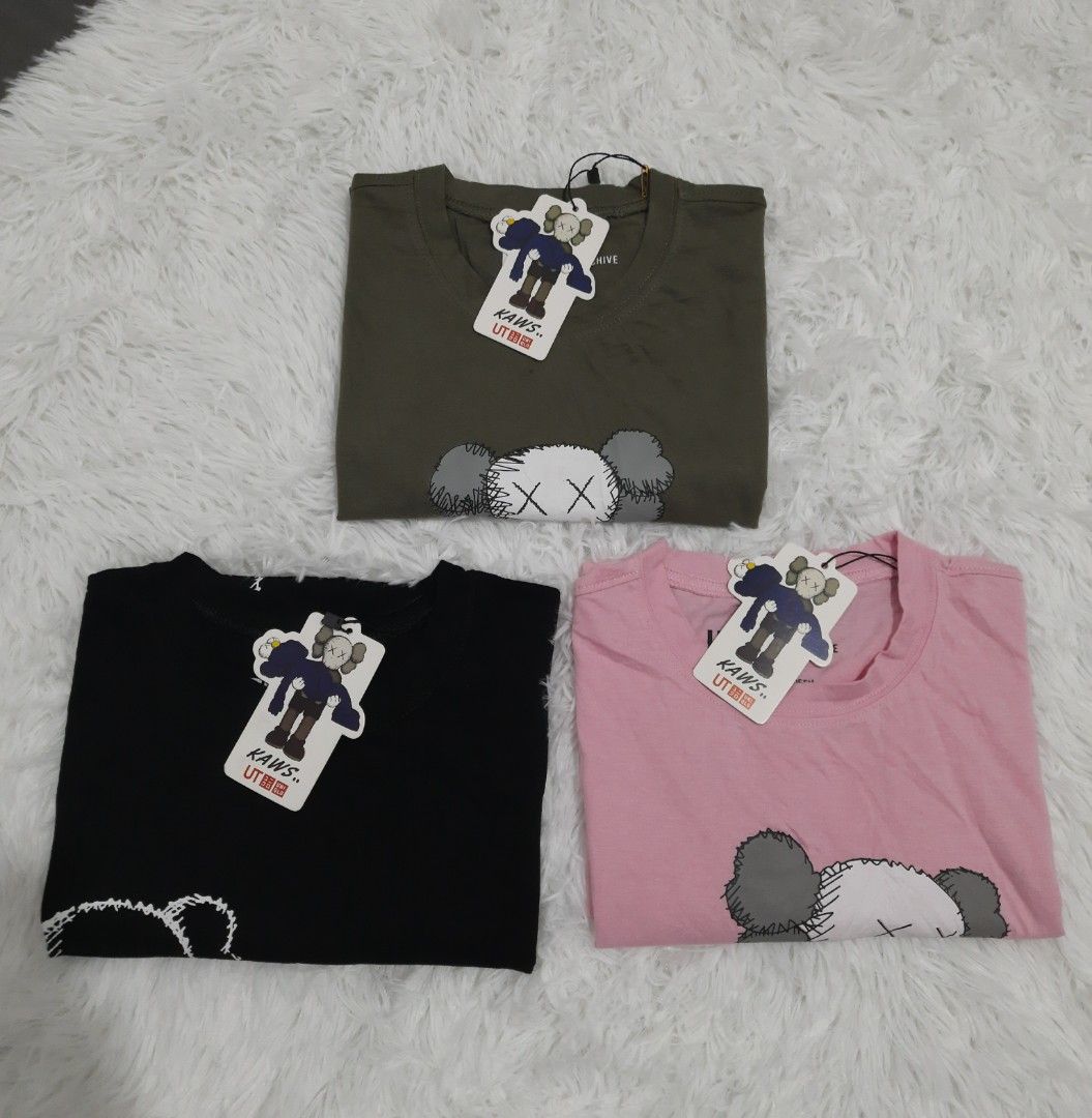 UniqloKaws Shirt as Pack (Category: Shirts) located in Victoria. Submitted by sharpthreads2025 (Listing ID 1355286404, Image 2). Description: Excellent Condition Important ‼️ The items are mall pull-out. Please manage your expectations. Has minimal flaws. S on tag Length: 22 in Width: 17 in Pink, Black, Moss Green Color rate: 10/10 Mode of payment: Gcash Courier: J&T Location: Laguna Note: SF shouldered by the buyer.