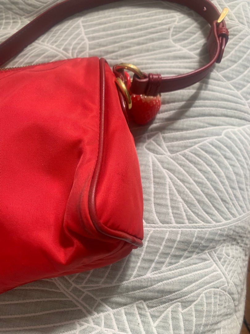 Authentic Prada red nylon shoulder bag (Category: Bags & Wallets) located in Perth. Submitted by salsa__ (Listing ID 1350945510, Image 3). Description: Authentic, purchased from vestiaire collective. I just don’t use it enough. Charms I added are included. No dust bag. Purchased in current condition. Corners worn, marks on the base and back of the bag. Zips function fine. Please message with any questions. Listed on depop also, check there to see