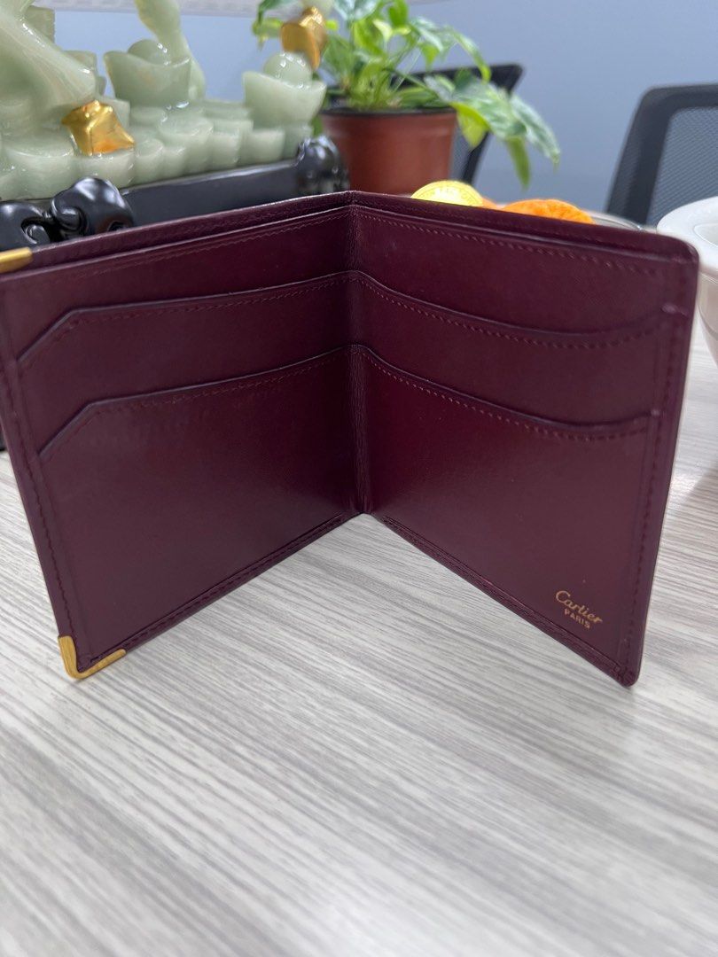 Authentic Cartier compact Wallet (Category: Luxury Bags & Wallets) located in Cagayan de Oro. Submitted by riggstuffs (Listing ID 1351327425, Image 3). Description: ➡️ Authentic Cartier Compact Wallet ➡️ calfskin material in burgundy color ➡️ exterior is in good condition with the embossed logo ➡️ Interior has 3 bill compartments ➡️ Rank A-AB in condition Disclaimer: Riggstuffs is not associated or affiliated with the brand posted. All copyrights