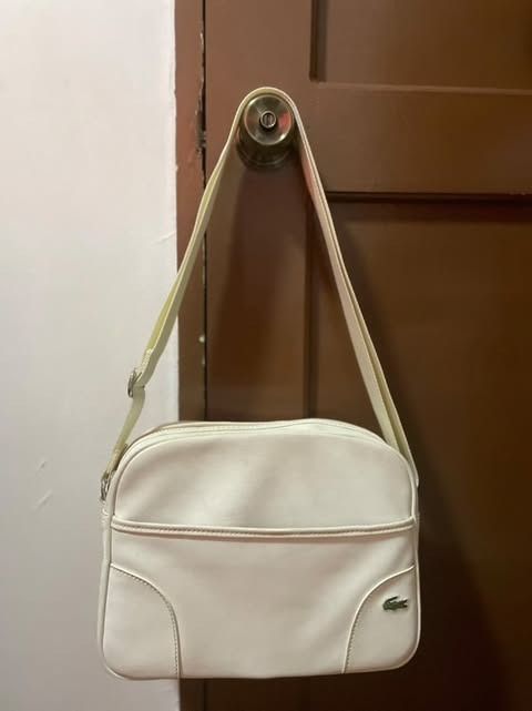 Authentic Lacoste White Cross-bag (Category: Luxury Bags & Wallets) located in Muntinlupa City. Submitted by d_everythingsnice (Listing ID 1351643852, Image 1). Description: Authentic Lacoste Cross Bag. - White in color - has black marks but could be wash or have it done by professional (please refer to the photos) - Good condition ang inner part - NO OTHER ISSUES aside sa nasa PHOTOS - Manage your expectations.