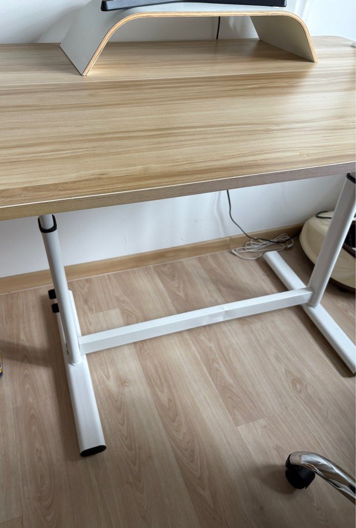 Adjustable study table (Category: Tables & Sets) located in Singapore. Submitted by shermtf (Listing ID 1357830927, Image 2). Description: Wooden table with adjustable legs. The leg part is slightly bent (during delivery). Dimensions: 100 cm (Length) x 70 cm (width), 75 cm (height) .