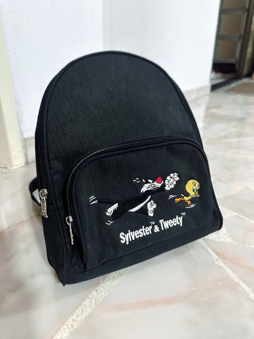 Backpack (Category: Backpacks) located in Singapore. Submitted by shersnug (Listing ID 1358752352, Image 3). Description: Upgrade your style with this Sylvester & Tweety™ Black Mini Backpack! Featuring a fun embroidered design of the classic cartoon duo, this compact yet spacious backpack is perfect for carrying your essentials. Made from durable fabric with adjustable straps and multiple zippered compartments, it’s ideal for casual outings, scho