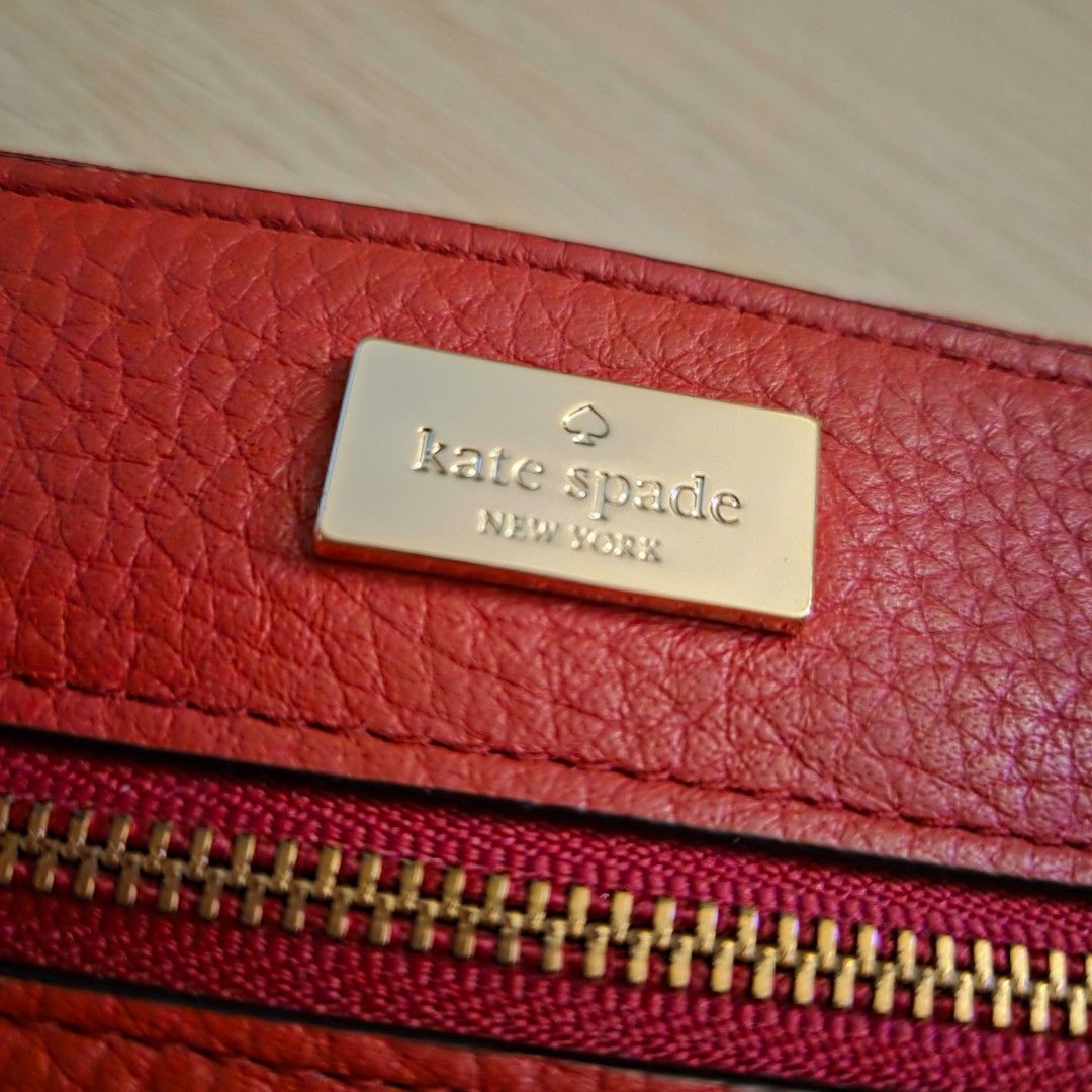 Kate Spade | Leather Wristlet Wallet (Red) (Category: Luxury Bags & Wallets) located in Quezon City. Submitted by m3262 (Listing ID 1358858185, Image 3). Description: • Unused; slightly old, but in good condition • Authentic; purchased from an official Kate Spade store in Hong Kong • No box included RFS: Decluttering Product details: • Dimensions: 6.5 x 4 inches • Pebble leather design • 1 main top zip compartment with wrist strap and 1 external 