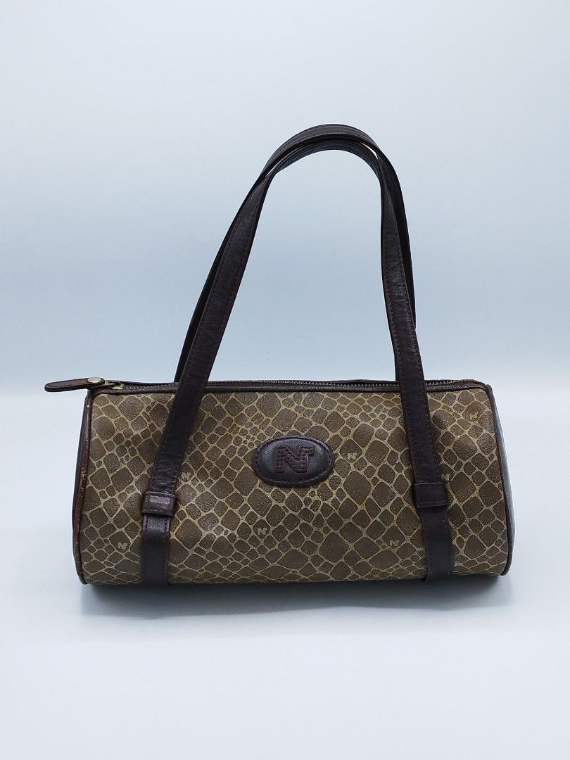 Nina Ricci Mini Barrel bag (Category: Luxury Bags & Wallets) located in Quezon City. Submitted by redragtag (Listing ID 1358747943, Image 1). Description: Authentic, vintage Nina Ricci bag in barrel shape Made in Italy Measurements: Height 10" x Length 5" Handle drop - 9.5" Description: - brown leather in pebbled prints and features the brand logo on the front - leather lining with open pocket - zip closure - 2 leather flat handles Condition: Ver