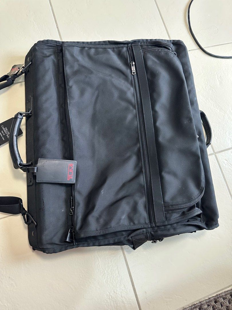 Tumi Alpha bi fold ballistic garment bag (Category: Luxury Bags & Wallets) located in Paranaque City. Submitted by tigerbomb (Listing ID 1359321564, Image 3). Description: Brand new bought in US Exterior Features: -Two U-zip pockets -Flat zip pockets -Back zip pocket -Top and bottom carry handles -Add-a-Bag sleeve -Removable shoulder strap Interior Features: -Garment curtain with zip pockets -Removable laundry bag -Shoulder pockets -Garment exten