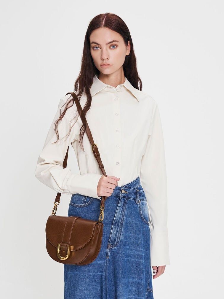 Charles and Keith Gabine Saddle Bag (Category: Cross-body Bags) located in Quezon City. Submitted by col.funshot (Listing ID 1359957117, Image 2). Description: Mall pullout item as claimed, bought from ig shop Medium size Brown color for that old money, casual everyday use Shoulder strap and crossbody strap Rfs: Rarely used Shipping fee c/o buyer No returns. Don’t transact if not sure.