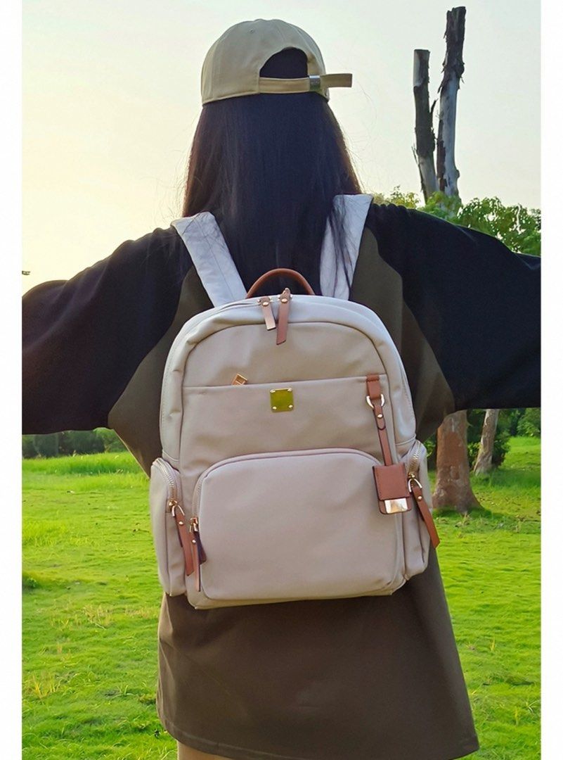Backpack (Category: Backpacks) located in Singapore. Submitted by perfect_three.sg (Listing ID 1360071840, Image 3). Description: Beige colour medium bag Size 25’12’35cm Like new , in perfect condition Multiple pocket Can hang on luggage 0.72kg.