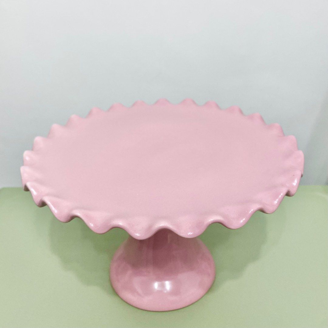 Pink Cake Stand (Category: Other Kitchenware & Tableware) located in Makati City. Submitted by aideclutter (Listing ID 1360557782, Image 1). Description: • Never Used • Material : Ceramic • Size : 10 inches (diameter) • Can fit 8-9 inch cake • Can also be used to hold cookies, cupcakes, donuts, & other pastries • Buyer shoulders DF • RFS : Decluttering • Discoloration on some parts have been present since it was bought. • Metro Manila delivery on