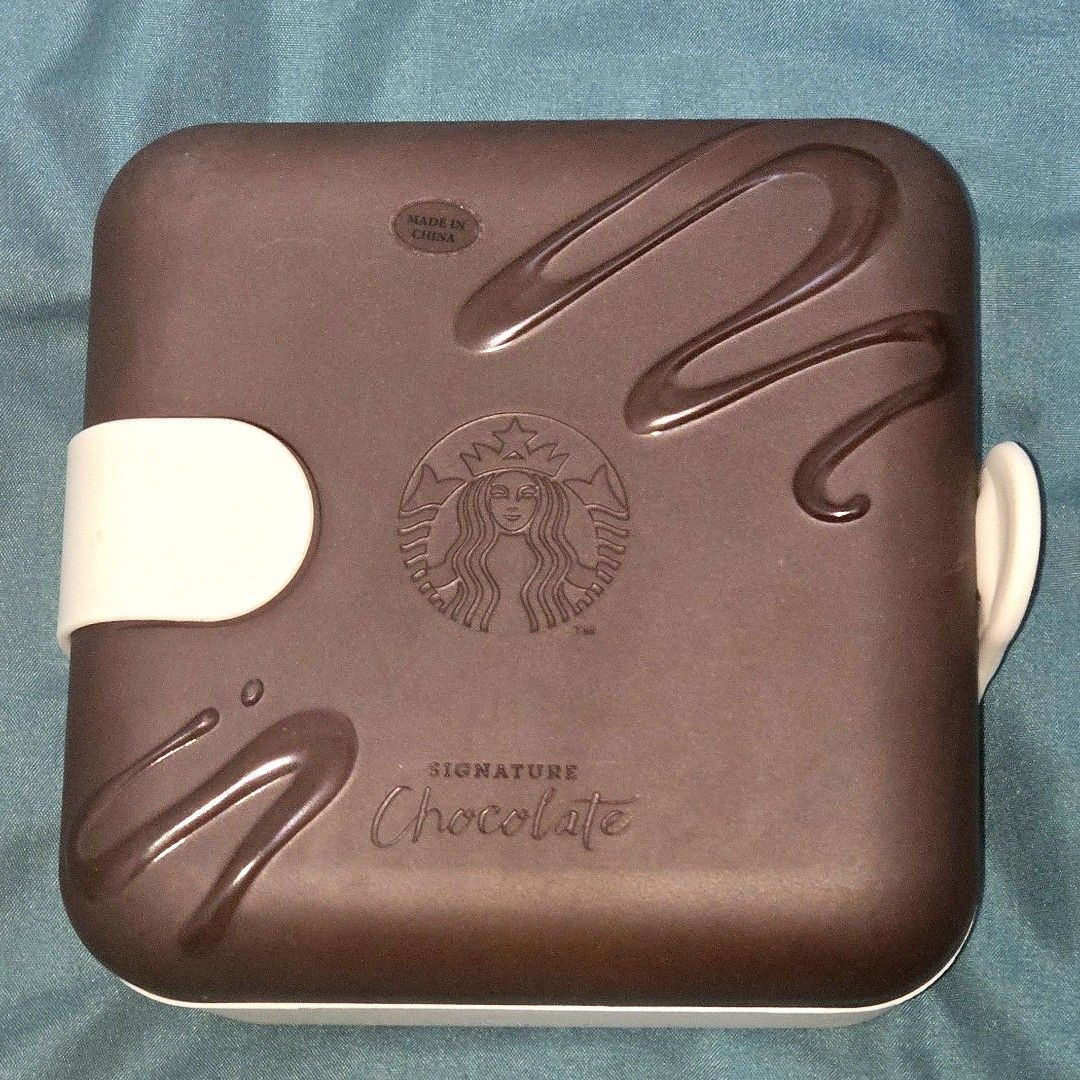 Starbucks Korea Dessert Box Original (Category: Food Organization & Storage) located in Antipolo. Submitted by wootteo1227 (Listing ID 1360538937, Image 1). Description: ✅Material: Melamine Resin, Silicon ✅Size: 14*14*8cm, 465g ✅️ new and unused - A stylish, square-shaped **dessert box** designed to resemble a chocolate bar, featuring a brown lid with a drizzled chocolate pattern. - Embossed with the Starbucks logo and the words **"Signature Choc