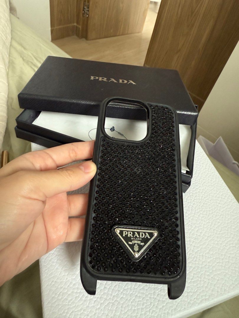 Authentic PRADA swarovski crystal studs case for iPhone 13/iPhone 14 Pro (Category: Cases & Sleeves) located in Makati City. Submitted by akr09 (Listing ID 1360748844, Image 2). Description: Full set with box, cards and receipt Good condition Prada cases for iPhone 13 and iPhone 14 Retail Price: white crystals- 25,000, black crystal case- 50,000 Note: White Crystal Case- with visible tarnishing on prada logo Black Crystal Case- with holes for pho