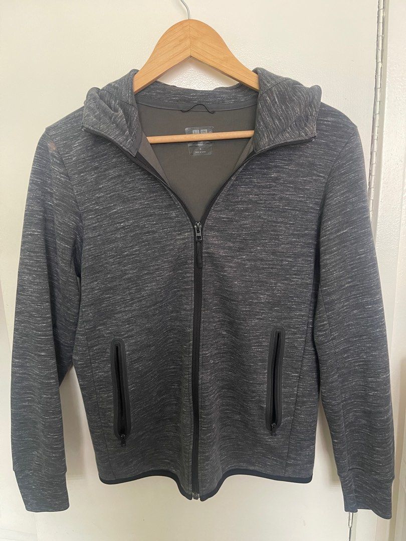 Uniqlo brand hooded jacket (Category: Coats, Jackets and Outerwear) located in Las Pinas. Submitted by chelfabs (Listing ID 1360918691, Image 1). Description: This is a Uniqlo brand hooded jacket in a size small. It features a dark gray heather color with a full front zipper closure. The jacket has long sleeves and two zippered pockets on the front. It is designed for casual wear and appears to be made of a comfortable, knit material..