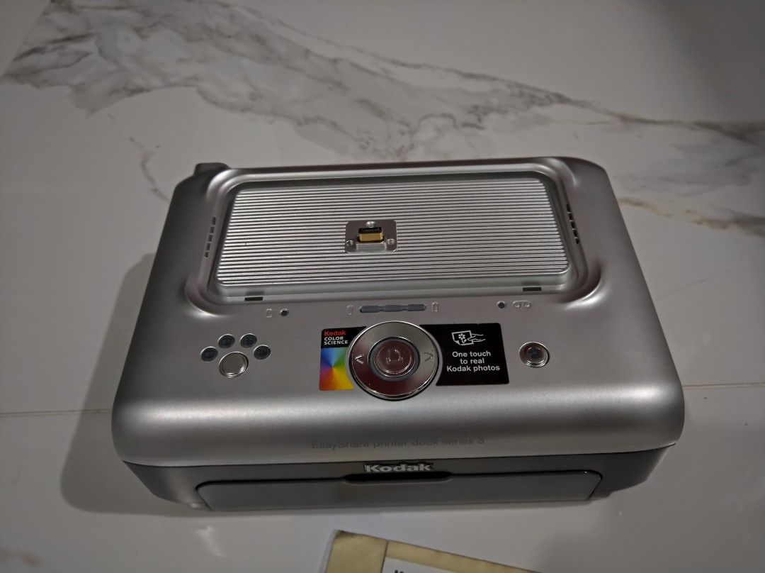 Kodak EasyShare Printer Dock Series 3 (Category: Other Photography Accessories) located in General Trias. Submitted by mervcorner (Listing ID 1361180720, Image 2). Description: Kodak EasyShare Printer Dock Series 3 - Working condition but ink cartridge included is broken. May nabibili sa s**pee pero bundled with photo paper kaya mahal. It can charge the camera while mounting on it. Please check your camera port is match with this dock pin. Sellin