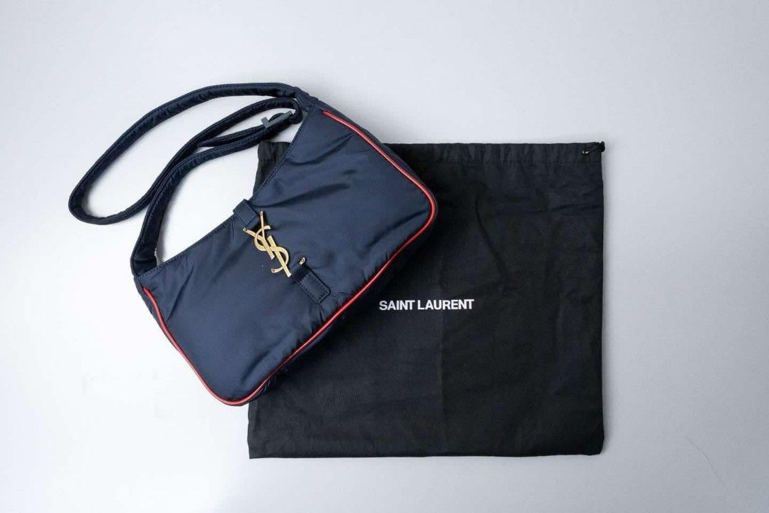 Auth YSL Nylon Bag Gold Hardware Shoulder Bag (Category: Luxury Bags & Wallets) located in Quezon City. Submitted by miyandabear (Listing ID 1356450682, Image 2). Description: guaranteed authentic 2x money back if proven fake original price at 170k+ bought in Shangrila Yves Saint Laurent Navy Blue nylon and red leather trim with gold hardware Includes: Booklet, authenticity card, dust bag Measurements: 9.5" L x 2.15" W x 6" H Interior Pockets: On