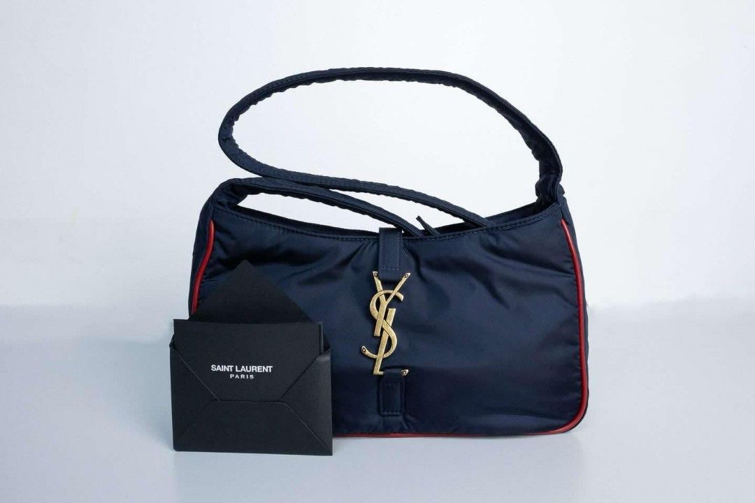 Auth YSL Nylon Bag Gold Hardware Shoulder Bag (Category: Luxury Bags & Wallets) located in Quezon City. Submitted by miyandabear (Listing ID 1356450682, Image 1). Description: guaranteed authentic 2x money back if proven fake original price at 170k+ bought in Shangrila Yves Saint Laurent Navy Blue nylon and red leather trim with gold hardware Includes: Booklet, authenticity card, dust bag Measurements: 9.5" L x 2.15" W x 6" H Interior Pockets: On