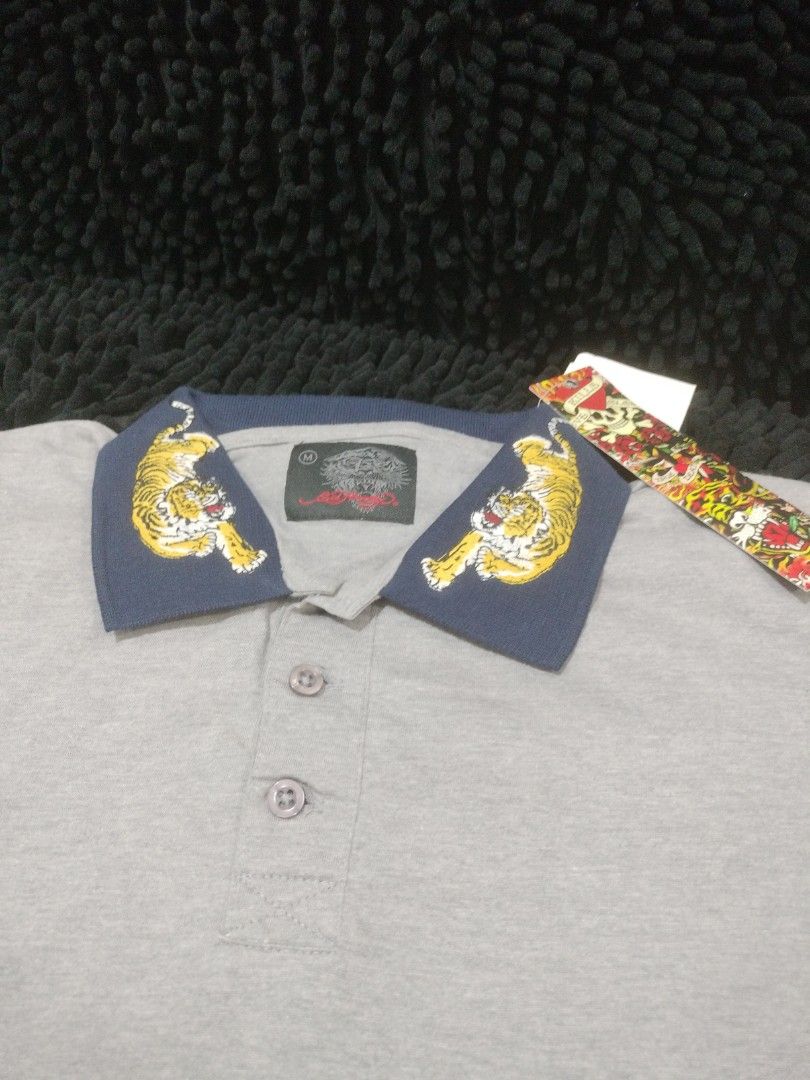 ED HARDY TIGER COLLAR POLO SHIRT (Category: Shirts) located in Mandaluyong City. Submitted by letgoph (Listing ID 1356568235, Image 2). Description: PLEASE READ WITH UNDERSTANDING. BRAND: ED HARDY Style: TIGER POLO SHIRT DEETS: Unisex Size: M on tag Dimension: 19 inches width 26 inches length 7 inches sleeves Color: Gray with embroidered tiger on dark blue collar Fabric: Cotton BNWT FLAW/S: None INCLUSION: Shirt only REASON FOR LETTING IT GO: Dec