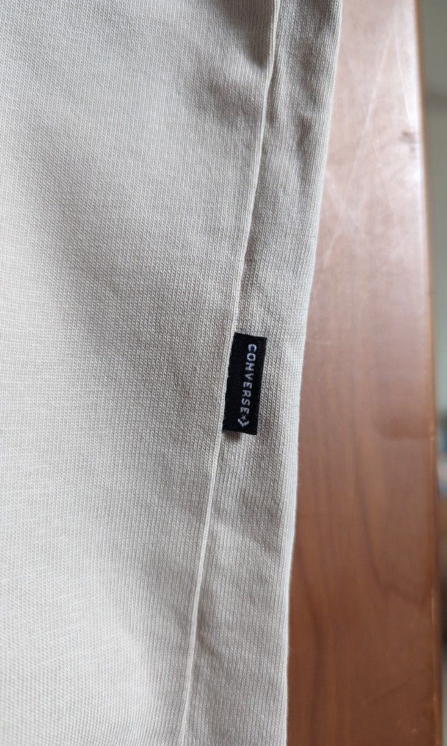 Converse Tee with Patch & Loop (Category: Tshirts & Polo Shirts) located in Singapore. Submitted by kerms_ (Listing ID 1357083712, Image 5). Description: Oversized Converse Tee in Tan. Bought from Overseas at Converse outlet. Has a furry patch and a small loop at the back of the shirt for details. Cotton material. Quick deal: $8 Length: 70 cm PTP: 60 cm Shoulder to shoulder: 55 cm RFS: Clearing wardrobe.