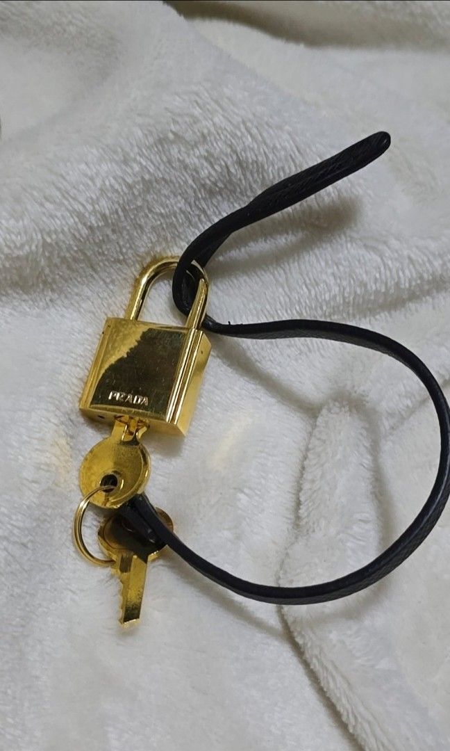 Authentic prada lock padlock from a leather handbag (Category: Luxury Accessories) located in San Juan City. Submitted by akioza (Listing ID 1357377241, Image 1). Description: (reduced to low simply bec. Im in mnl at the moment... just visiting occasionally to care for elderly relatives) lovely. gold. unisex. with its black leather tag 2 keys. all working condition is great, it's been stored lang with other trinkets and knick knacks in my old roo
