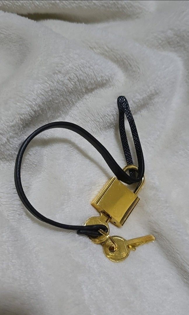 Authentic prada lock padlock from a leather handbag (Category: Luxury Accessories) located in San Juan City. Submitted by akioza (Listing ID 1357377241, Image 2). Description: (reduced to low simply bec. Im in mnl at the moment... just visiting occasionally to care for elderly relatives) lovely. gold. unisex. with its black leather tag 2 keys. all working condition is great, it's been stored lang with other trinkets and knick knacks in my old roo
