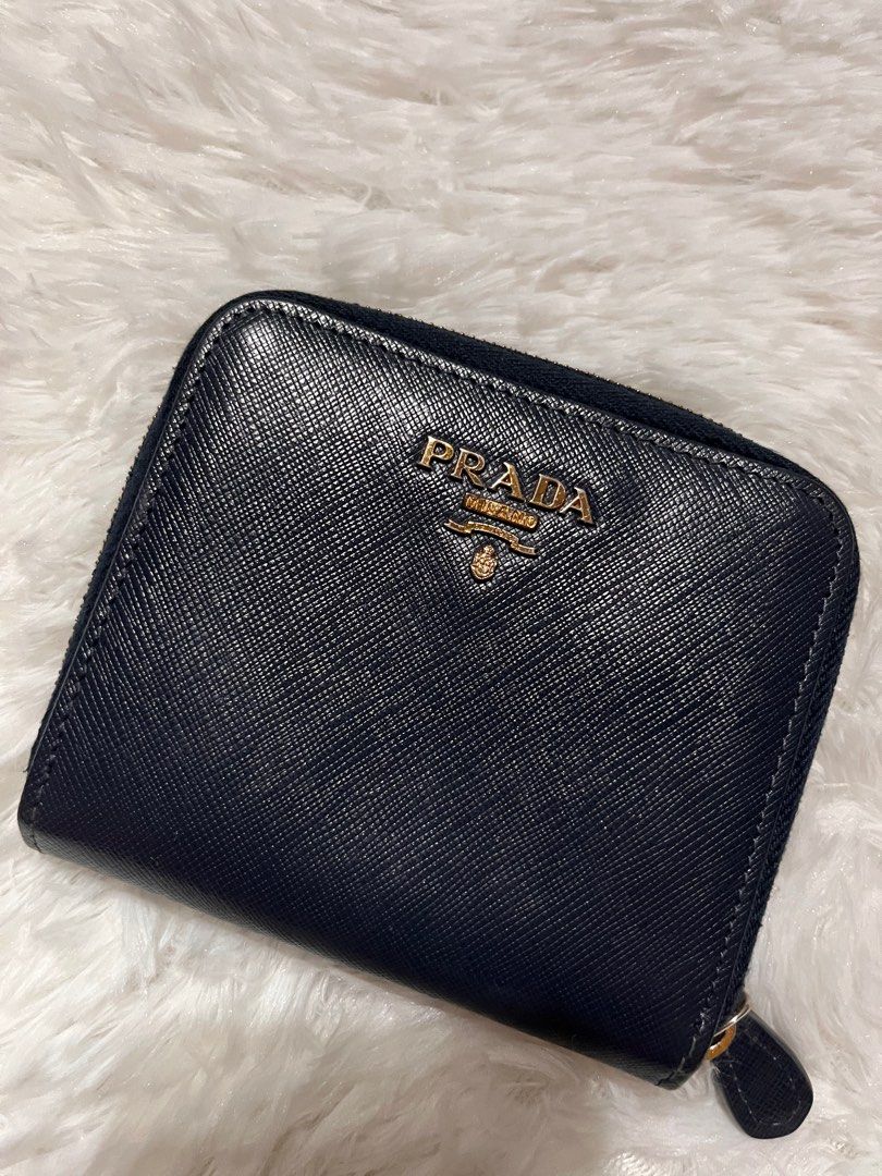 MUST GO! AUTH PRADA BIFOLD WALLET (Category: Luxury Bags & Wallets) located in Pasay City. Submitted by lovefashionstuff (Listing ID 1338900389, Image 2). Description: color: navy blue guaranteed 💯 authentic bi-fold saffiano leather with signs of use but well used inclusions: wallet only 4x4 inches no to bogus buyers..