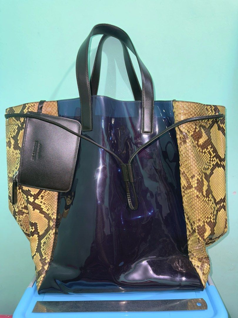 Auth Jil Sander Python/PVC Tote Bag (Category: Luxury Bags & Wallets) located in Cavite. Submitted by okaypreloved (Listing ID 1363700557, Image 1). Description: 2012 Runway Piece by Raf Simons for Jil Sander FLAWS Signs of usage Expired strap adhesive of pouch (ex pic 6) Expired Edge Seal of leather handles (ex pic 7) *PVC appears purplish *MEET-UP ONLY ALL SALES ARE FINAL AND NONRETURNABLE.