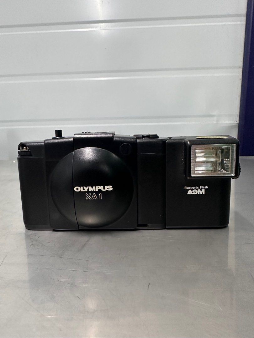 Olympus XA (selenium) with A9m flash (Category: Cameras) located in Manila. Submitted by dominicju40682 (Listing ID 1363854830, Image 1). Description: Olympus XA (selenium) with A9m flash Shutter working, aperture changes according to light exposure Winding and film advance okay Viewfinder kinda foggy Issues: A9M not working, only makes charging noise but does not produce flash/illumination Crack on the plastic near the film advance wheel Still s