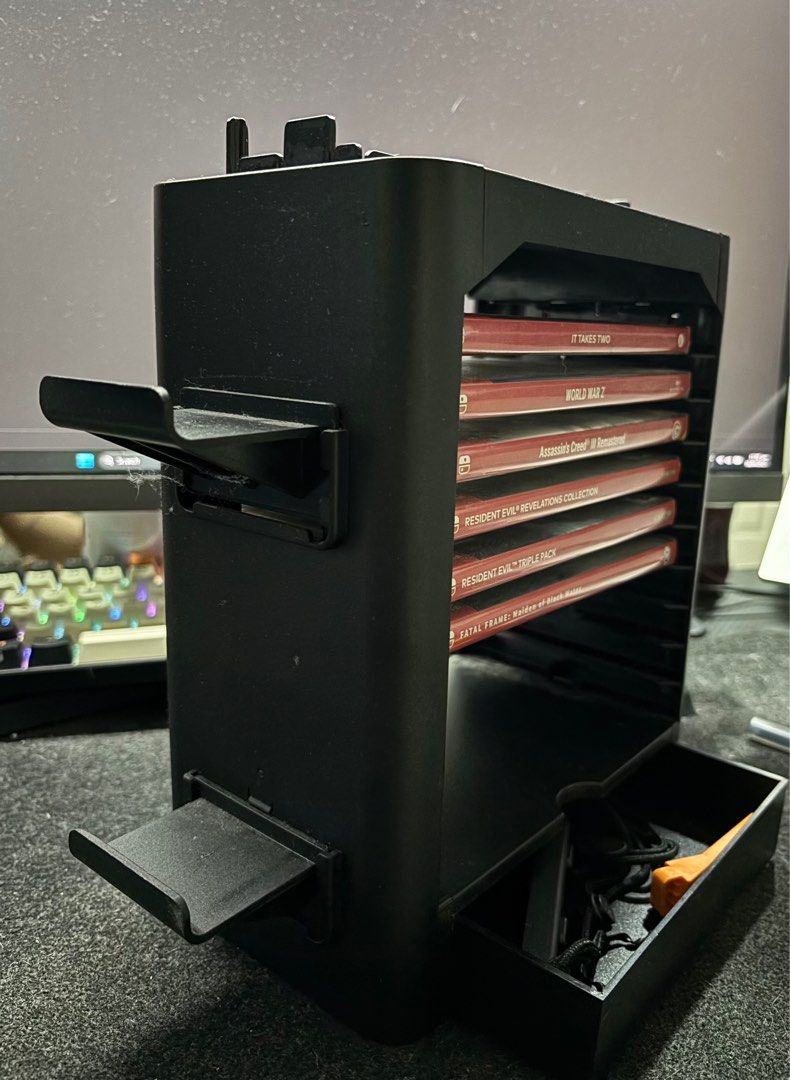 JYS One-Stop Multifunctional Game Storage Tower for Nintendo Switch (Category: Cases & Covers) located in Manila. Submitted by acl0413 (Listing ID 1364380892, Image 3). Description: - with controller holder on both sides - with mini storage - can hold up to 10 games - switch TV dock can be stacked on top.