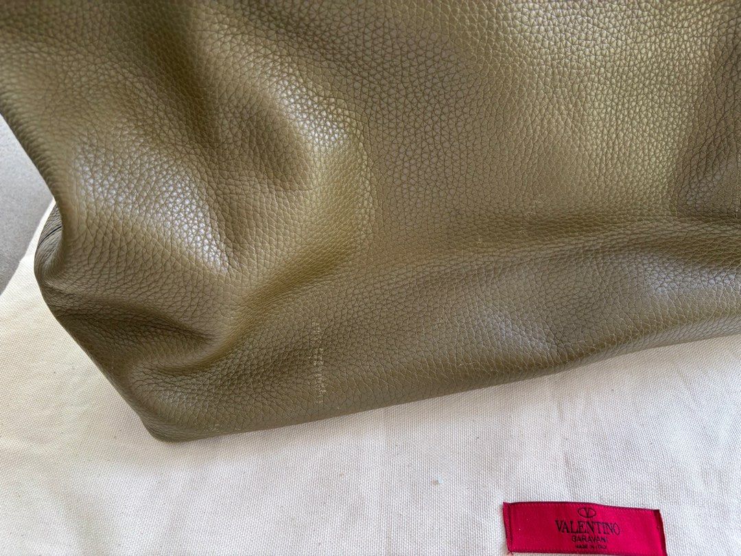 Valentino Rockstud Tote Bag (Category: Bags & Wallets) located in Singapore. Submitted by tsutsipop (Listing ID 1364248371, Image 3). Description: I'm clearing my closet and selling my well loved Valentino Tote. Scratches and tears throughout, they are all indicated in the pics. Not for fussy buyers!! Purchased for ~1,600 SGD, letting go for less than 20% of original price! Dimensions: 48cm (width) x 28cm (height) x 12cm (depth) Contains RFID tag