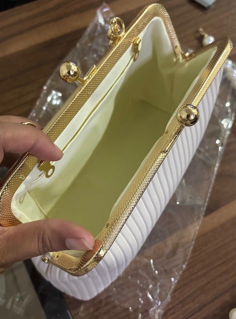 White hand bag (Category: Clutches) located in Mandaluyong City. Submitted by bea_dc (Listing ID 1364780853, Image 2). Description: + used once (wedding party) + has a pocket on the inside, PU Leather, kiss lock closure.
