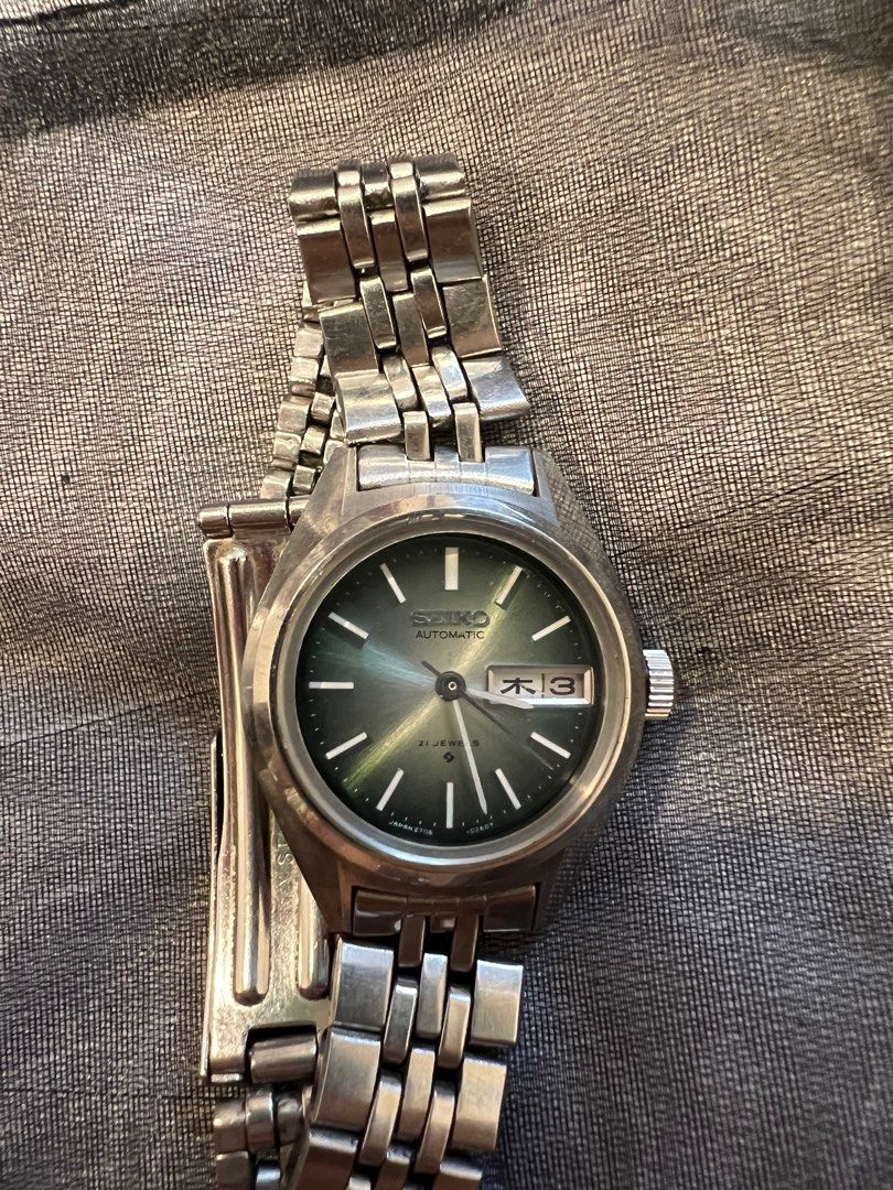 Seiko ladies 21 jewels day date watch (Category: Women's Watches) located in Singapore. Submitted by filanthropy (Listing ID 1365374940, Image 1). Description: Ladies seiko watch with pretty green gradient dial, 23mm case size and 30mm lug to lug. Has both english and japanese day settings. Watch is used but in working condition with minor scratches. Wrist circumference up to 15.5cm, no extra links provided..