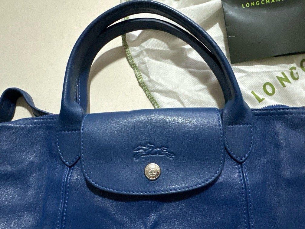 Longchamp Le Pliage Blue Full Leather Bag (Category: Bags & Wallets) located in Singapore. Submitted by japalang_shop (Listing ID 1365917146, Image 2). Description: 100% authentic, full leather. Brand new with receipt. Lightweight, foldable and compacts can hand carry can sling. Perfectly convenient and understated bag 39cm x 24cm.