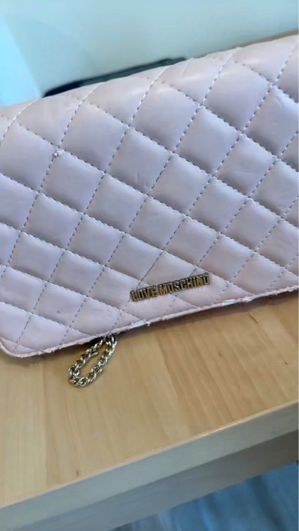 Love Moschino Quilted Chain Bag (Category: Bags & Wallets) located in Singapore. Submitted by lhsa91 (Listing ID 1366415536, Image 3). Description: This Love Moschino quilted chain bag is a stylish and practical option for everyday use. It features a classic quilted design and a gold chain strap. The bag is in well-used condition, with wear and tear on the edges. The button still works very well and the inside is in good condition. The chain is a