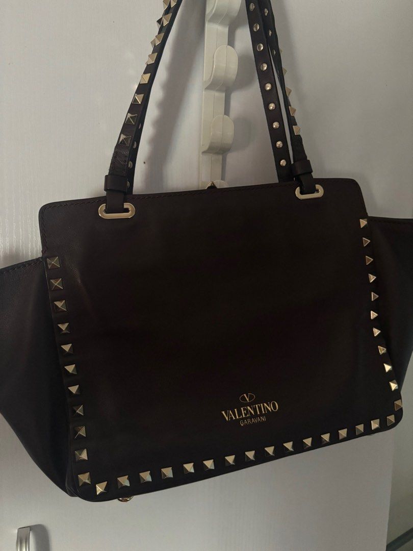 Valentino Rockstud Trapeze bag small (Category: Luxury Bags & Wallets) located in Makati City. Submitted by bravelion_cea1db (Listing ID 1362232715, Image 2). Description: Valentino Rockstud Trapeze bag small Color : dark eggplant 🍆 Gold hardware With dustbag and cards RFS: Decluttering .