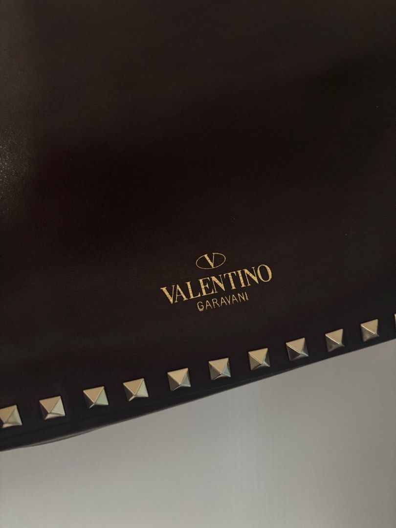Valentino Rockstud Trapeze bag small (Category: Luxury Bags & Wallets) located in Makati City. Submitted by bravelion_cea1db (Listing ID 1362232715, Image 3). Description: Valentino Rockstud Trapeze bag small Color : dark eggplant 🍆 Gold hardware With dustbag and cards RFS: Decluttering .