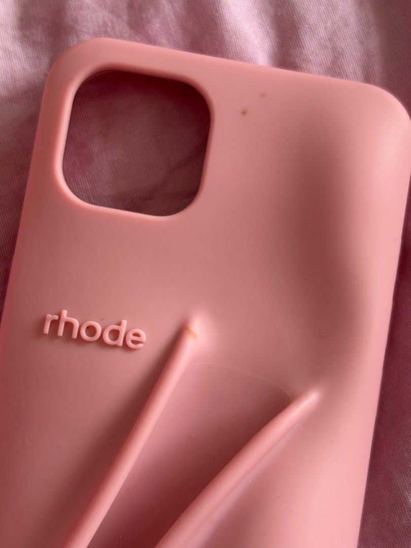 Authentic Rhode iPhone 13 Lip Case in Ribbon (Category: Cases & Sleeves) located in Makati City. Submitted by michi_ (Listing ID 1362537485, Image 2). Description: Original! Bought it during my last trip to NY from the rhode website. Out of stock already :( has some flaws: - two small stains from a henna tattoo haha :((( maybe you can take it off pa - small unnoticeable tear on the corner (came like that) RFS: Upgraded to a new phone.