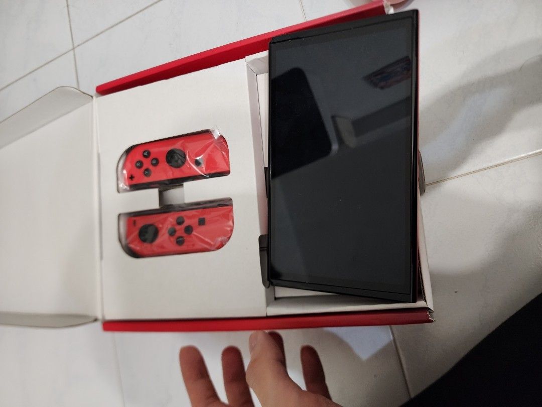 Switch oled red (Category: Nintendo) located in Singapore. Submitted by wildtiger_3bb1c1 (Listing ID 1368254322, Image 2). Description: include basic accessories, box and charger and joycon.
