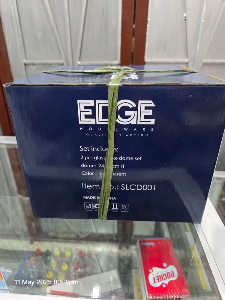 Edge Houseware Round Glass Cake Dome (Category: Other Kitchen Appliances) located in Santa Rosa. Submitted by dlsud0708 (Listing ID 1368652428, Image 3). Description: BRAND NEW!!! The item is an Edge Houseware Round Glass Cake Dome, part of the Edge Flower Collection Series, specifically the Sunflower Design. Kew Features include: - Material: Glass dome and likely a bamboo base. - Purpose: Protects cakes and pastries from dust and debris while el
