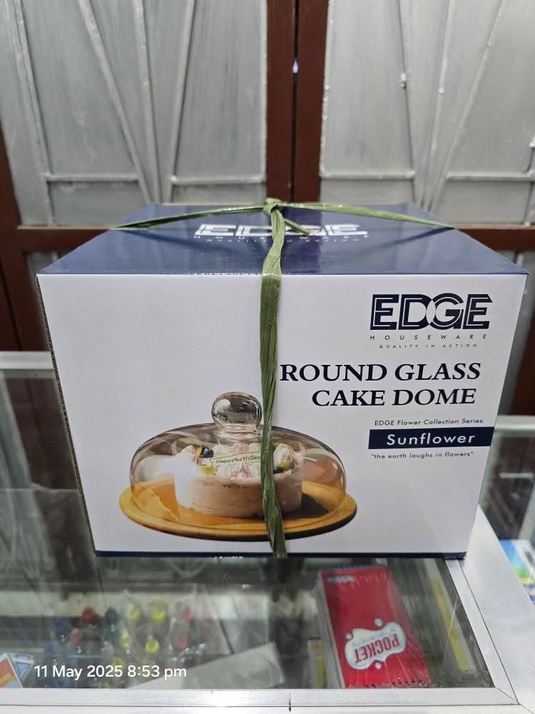 Edge Houseware Round Glass Cake Dome (Category: Other Kitchen Appliances) located in Santa Rosa. Submitted by dlsud0708 (Listing ID 1368652428, Image 1). Description: BRAND NEW!!! The item is an Edge Houseware Round Glass Cake Dome, part of the Edge Flower Collection Series, specifically the Sunflower Design. Kew Features include: - Material: Glass dome and likely a bamboo base. - Purpose: Protects cakes and pastries from dust and debris while el