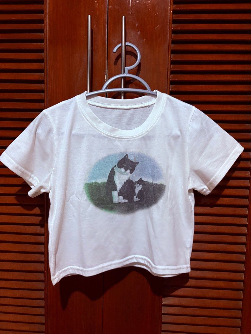 Cat Baby Tee (SHEIN) (Category: Shirts) located in San Mateo. Submitted by piscesdotcom (Listing ID 1368942267, Image 1). Description: size xs-s has stain (check 2nd photo) cutest fit and design rfs: too many white tops mop: gcash mod: ggx / lalamove.