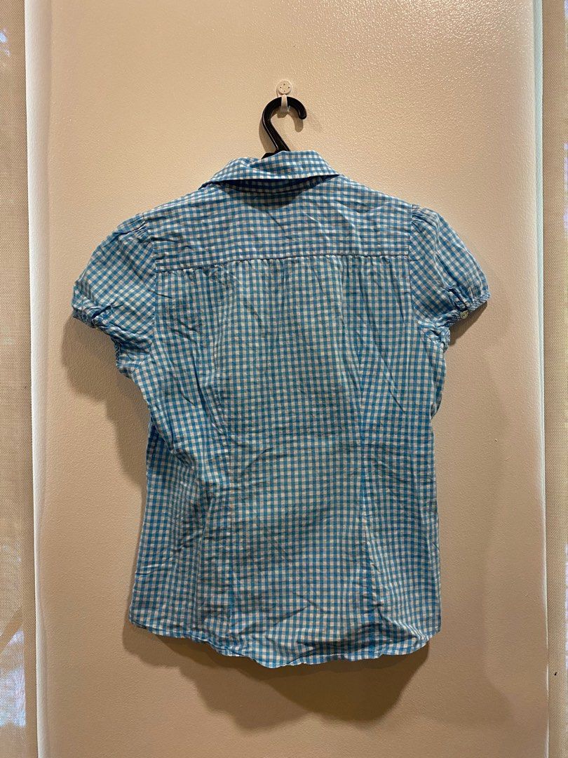 y2k light blue gingham button up polo top (Category: Shirts) located in Pasig City. Submitted by s0phiesells (Listing ID 1369553661, Image 2). Description: super trendy brandy inspired top, in perfect condition, and thrifted!! so so cute as in, must buy talaga🤩💞 s-m frames !!.