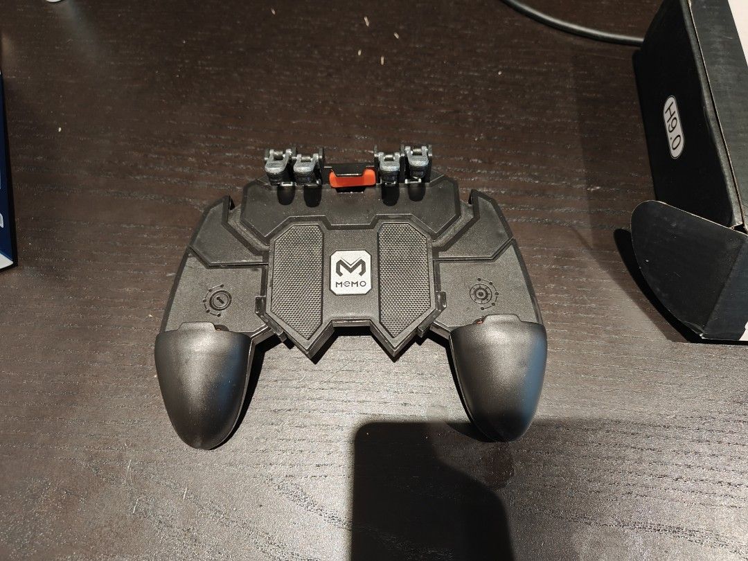 mobile game controller (Category: Other Gadgets) located in Singapore. Submitted by kitbank (Listing ID 1369780970, Image 2). Description: Bought a lot for my Pubg, and now don't play this game any more Can put you phone on it and help you eat the chicken dinner 😂 Didn't use. 5 dollars each.