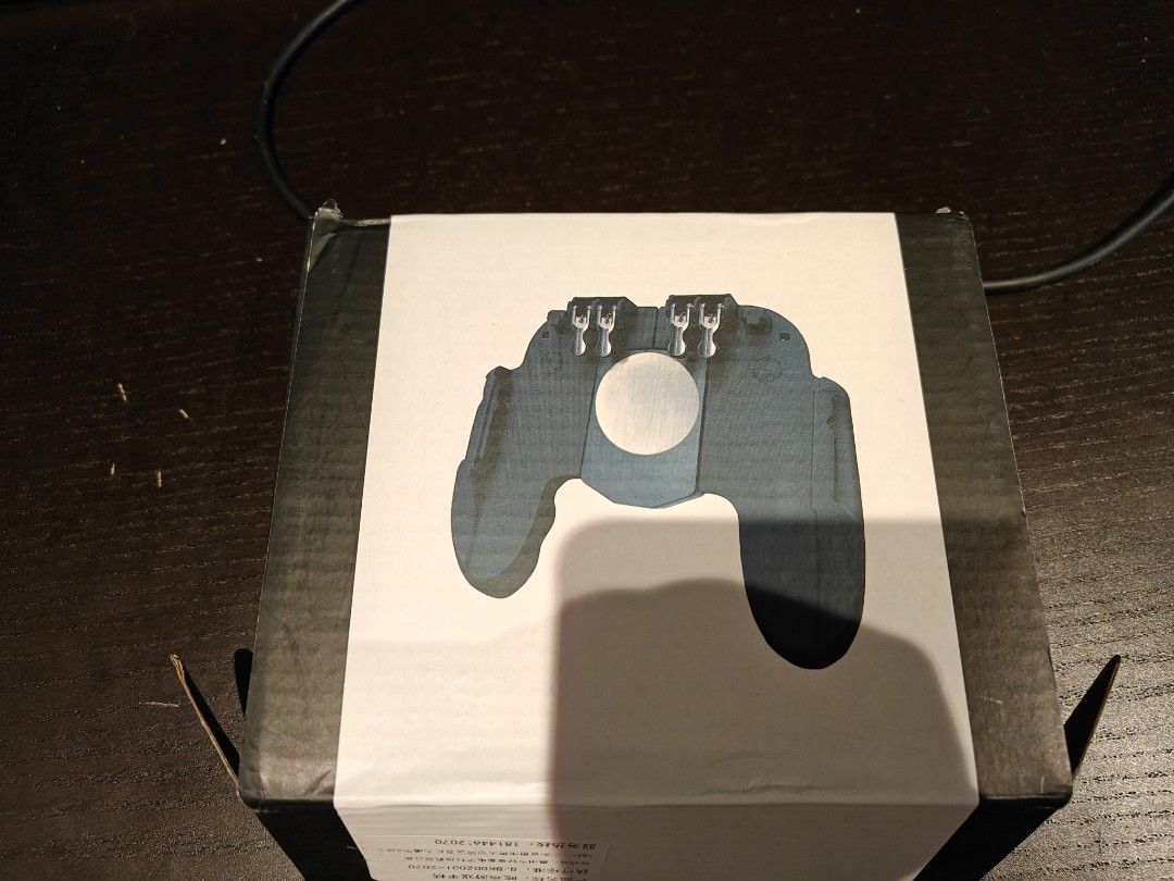 mobile game controller (Category: Other Gadgets) located in Singapore. Submitted by kitbank (Listing ID 1369780970, Image 3). Description: Bought a lot for my Pubg, and now don't play this game any more Can put you phone on it and help you eat the chicken dinner 😂 Didn't use. 5 dollars each.