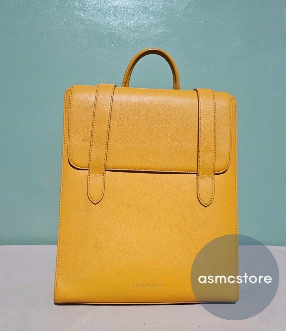 Strathberry Backpack in Yellow (Category: Luxury Bags & Wallets) located in Marikina City. Submitted by asmcstore (Listing ID 1369989290, Image 1). Description: Strathberry Backpack in Yellow Style is already sold out Made in Spain There are some cracks on the rubber linning as seen on photo Length: 31 cm Width: 27 cm Depth: 9 cm **These are VINTAGE/PRELOVED bags signs of usage might be present** **Bags are cleaned and conditioned**.